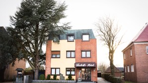 Un hotel con fachada de ladrillo, un letrero que dice 'Falk's Hotel' y una entrada con portones.