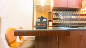 Una cocina compacta con un mueble de madera, una encimera negra y una bolsa de viaje con la etiqueta 'Travelio'.