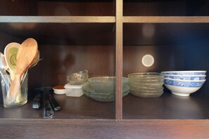 A wooden cabinet with glassware and bowls.