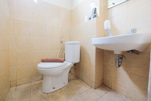 A bathroom with a toilet, sink, and tiled walls.