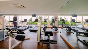 Una palestra con tapis roulant, macchinari per pesi e uno specchio a parete.