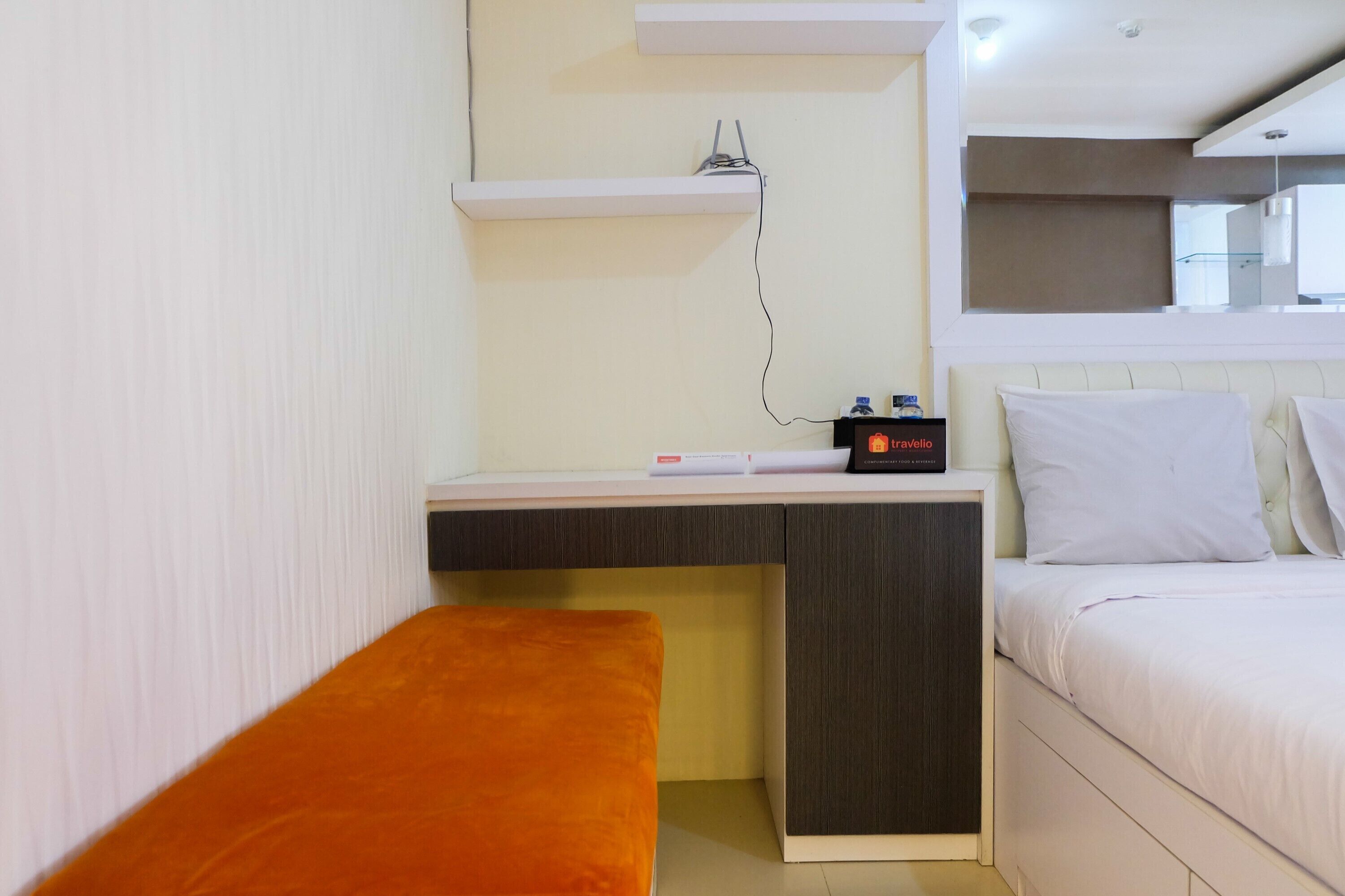 A bedroom with a bed, a desk, and a bench.