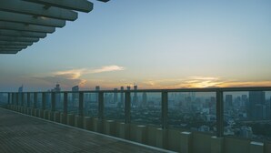 A high-rise building with a panoramic view of a cityscape at sunset. - Comfortable and Modern 2BR Menteng Park Apartment (Jakarta)