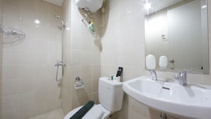 A bathroom with a shower, toilet, sink, and mirror. - Clean and Cozy 2BR Apartment @ Parahyangan Residence (Bandung)