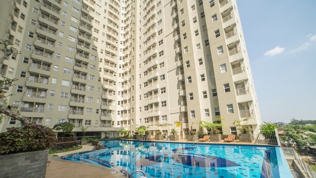 A high-rise residential building with a swimming pool. - Clean and Cozy 2BR Apartment @ Parahyangan Residence (Bandung)
