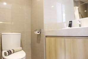 A modern bathroom with a toilet, a towel, a mirror, and a shower curtain.