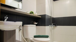 A bathroom with a toilet, sink, and shower.
