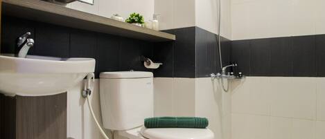 A bathroom with a toilet, sink, and shower.