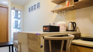 A kitchen with a countertop, a chair, a coffee maker, and a box labeled 'Travelio'.