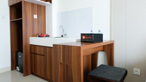 A modern kitchenette with a wooden countertop, a sink, and a bench. - Homey Studio Room Tree Park Apartment near BSD City (South Tangerang)