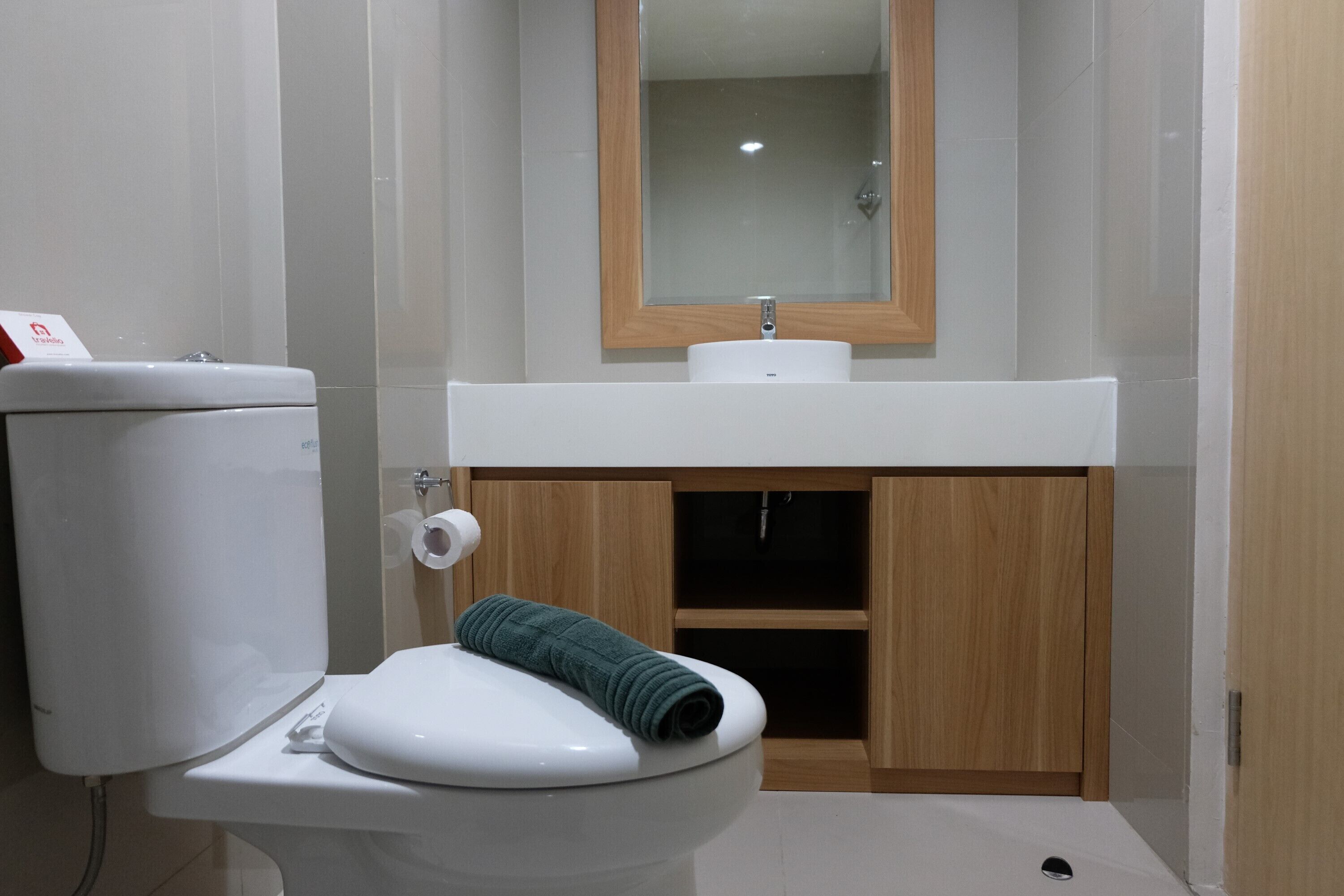 A modern bathroom with a toilet, sink, and mirror.