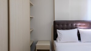 Un dormitorio con cama, mesita de noche y armario.