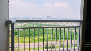 A balcony with a metal railing overlooking a cityscape with buildings and greenery. - Highest Value 2BR at Great Western Apartment (Tangerang)