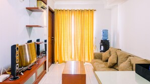A living room with a TV, a coffee machine, and a water dispenser. - Highest Value 2BR at Great Western Apartment (Tangerang)