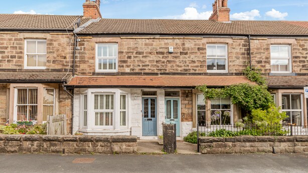 A row of stone terraced houses with a central entrance, each with a distinct door color and window design. - Strayside Cottage Harrogate. Dog friendly. 5 min walk hospital. 15 min walk town (Harrogate)