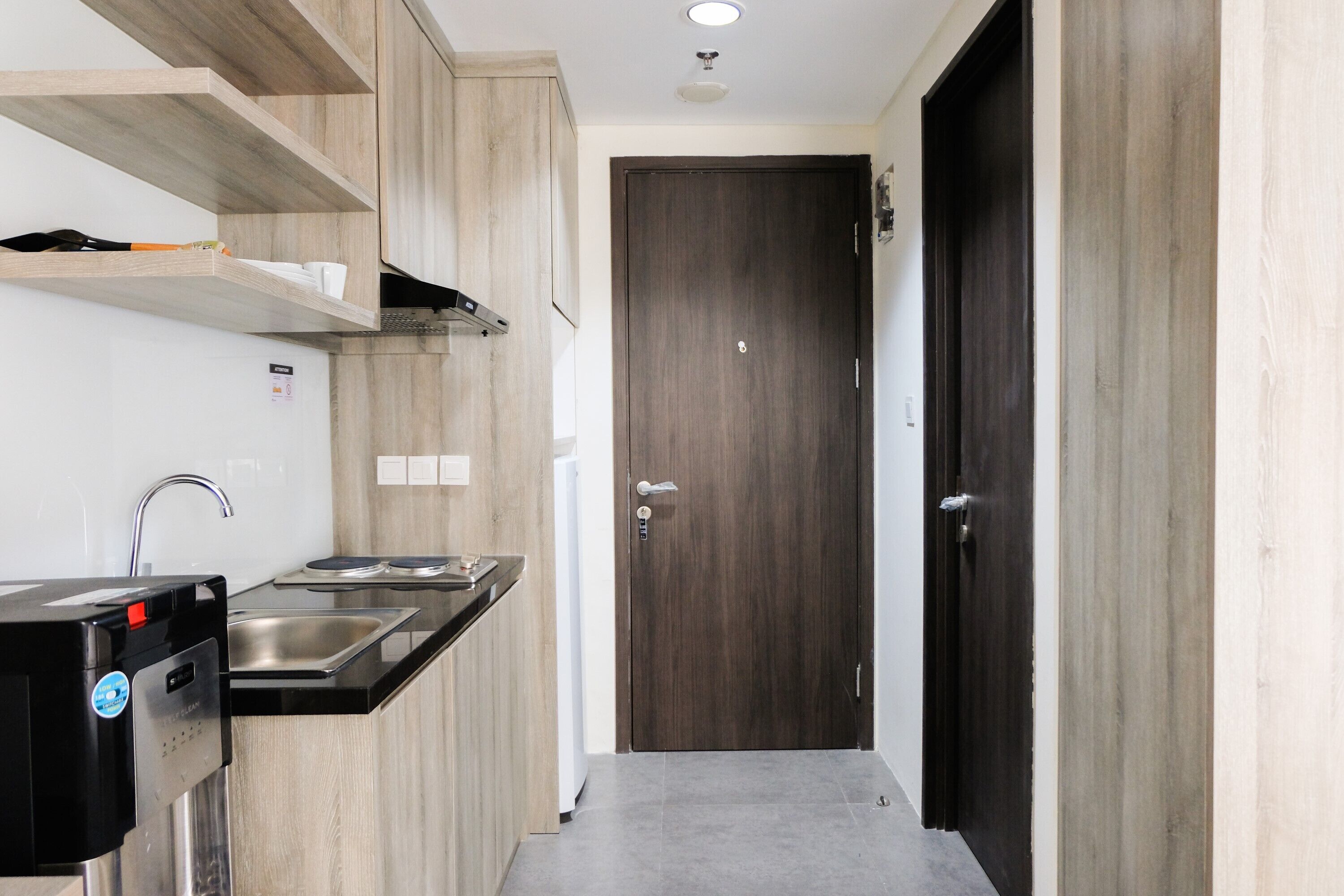 A modern kitchen with wooden cabinets, a built-in stove, and a sink.