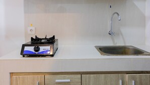 Una cocina con estufa a gas, un lavamanos y armarios de madera.