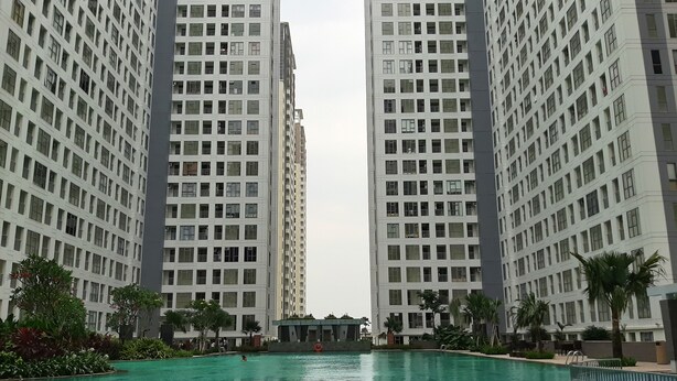 Une piscine entourée d’immeubles d’habitation de grande hauteur.