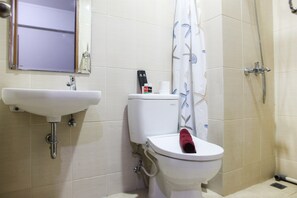 Bathroom features a sink, toilet, and shower with a shower curtain.