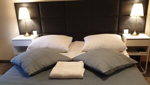 A neatly made bed with a dark headboard, two bedside tables with lamps, and multiple pillows. - Willa Azalia (Polanica-Zdroj)