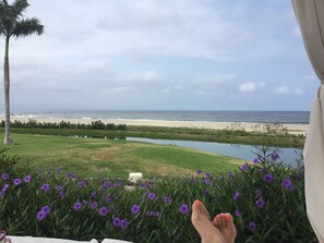 Guests can enjoy a tranquil beach view from this serene outdoor setting.