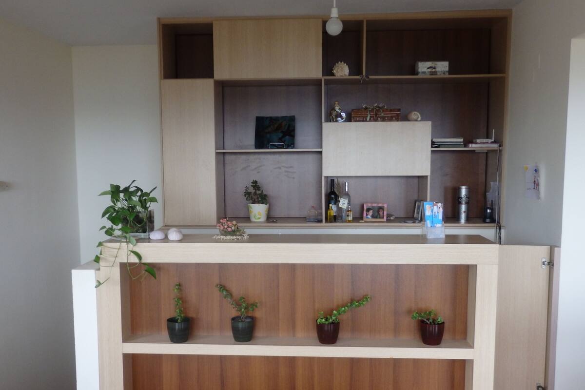 Una cocina con armarios de madera, una encimera y plantas en macetas.