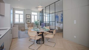 A modern kitchen with a dining area, large windows, and a view into the living room. - Liiiving in Porto| Luxury Beachfront Apartment III (Porto)
