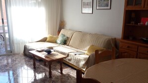 Una sala de estar con un sofá, una mesa de comedor y un aparador.