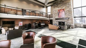 A spacious lobby with a stone wall, a fireplace, and a reception desk. - Prospector Studio - Slps 4 (Park City)