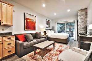 A modern bedroom with a bed, a sofa, a coffee table, and a view of the outdoors. - Prospector Studio - Slps 4 (Park City)
