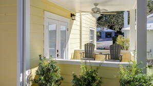 A yellow house with a porch, two chairs, and a ceiling fan. - The Carlton* 3 min walk to Downtown Mt. Dora!!  (Mt Dora)