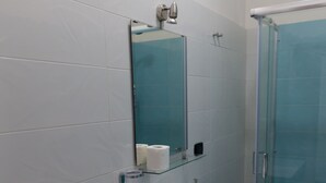 A bathroom with a white sink, a glass shower enclosure, and a white toilet.