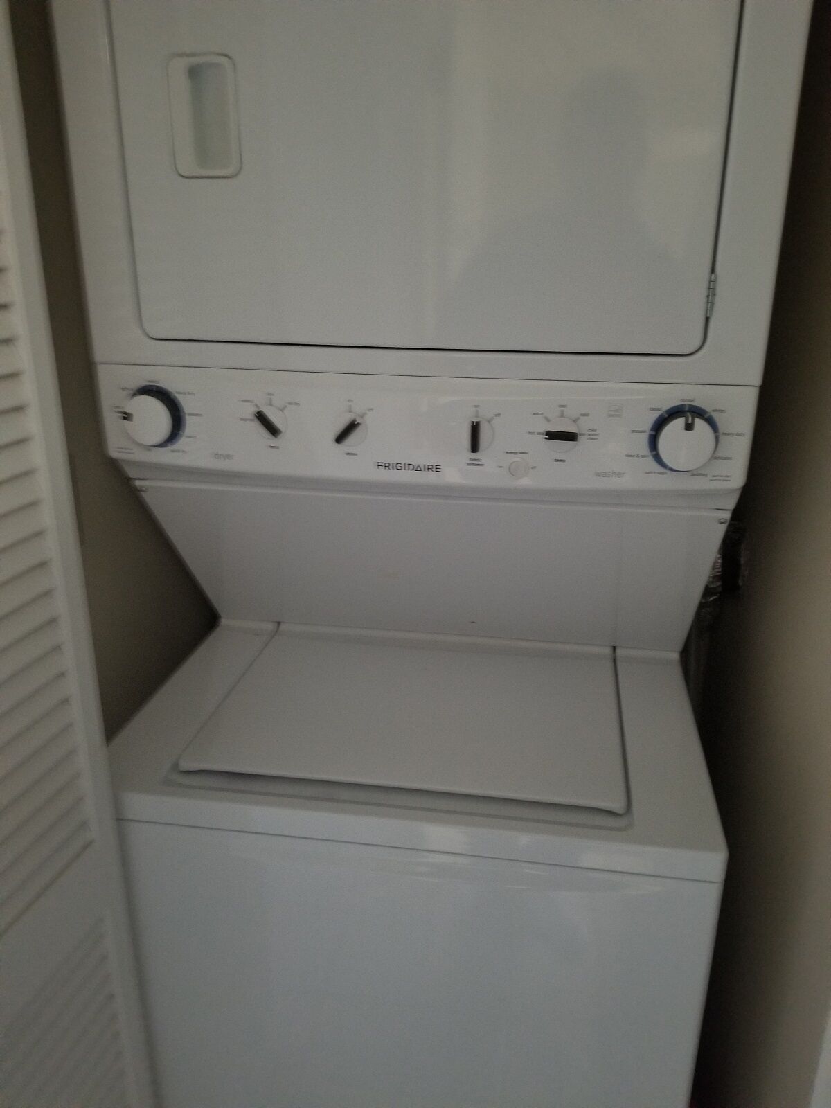 A compact, white laundry machine with multiple control knobs and a front-loading door.