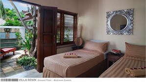 Ein Schlafzimmer mit zwei Betten, einem großen Spiegel und Blick auf einen Garten.
