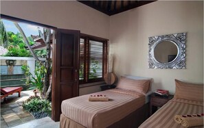 Une chambre avec deux lits, un grand miroir et une vue sur un jardin.