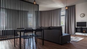 A modern living room with a sofa, dining table, chairs, and a TV. - Round loft (azibo) (Macedo de Cavaleiros)