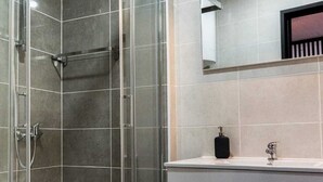 A modern bathroom with a glass-enclosed shower, a vanity with a mirror, and a countertop. - Round loft (azibo) (Macedo de Cavaleiros)