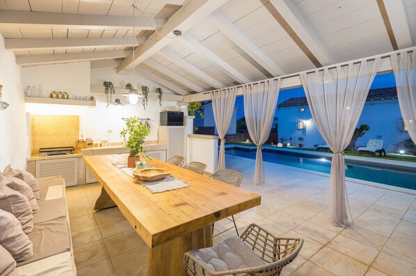 Enjoy a meal for two at this outdoor dining space, complete with a kitchen and adjacent pool.