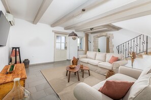 Relax in this stylish living room with a sofa, coffee table, and large rug, surrounded by a high ceiling and stone archway.