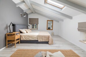 Relax in this serene bedroom with a large bed, bedside tables, and a mirror.