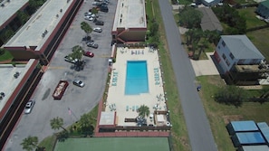 An aerial view of a hotel with a swimming pool, a parking lot, and a road. - Pelican Inlet B115 (St. Augustine)