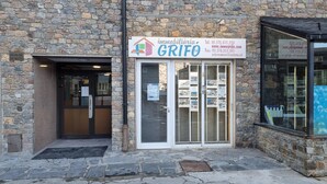 En bygning i sten med et skilt for 'GRIFO imobiliária', der viser kontaktoplysninger.