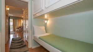 A bunk bed with a green mattress in a room with light blue walls.