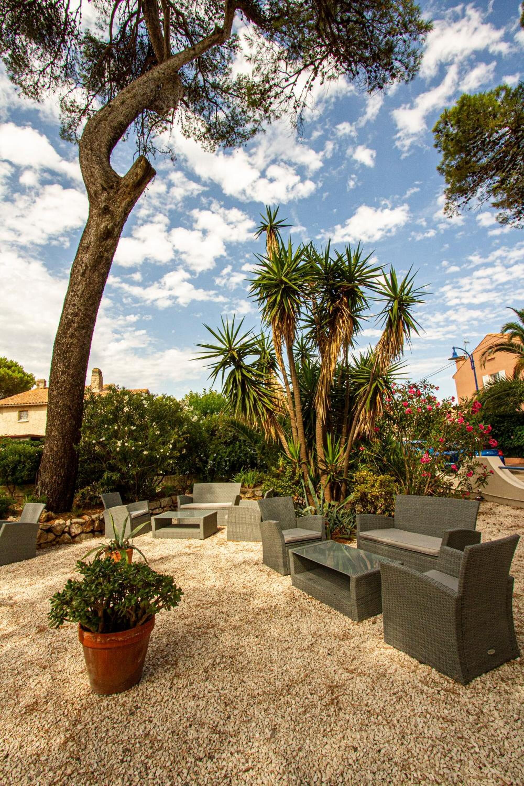 An outdoor seating area with wicker furniture and a potted plant.