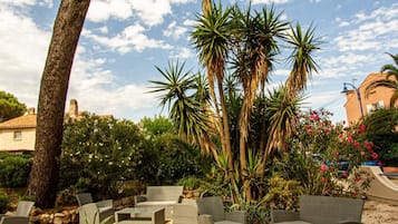 An outdoor seating area with wicker furniture and a potted plant.