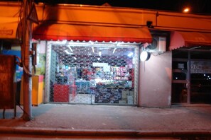 Storefront with a metal fence and red awning.