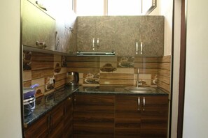 Kitchen features a range hood, stainless steel sink, and patterned tile backsplash.