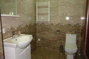 Bathroom features a pedestal sink, toilet, and towel rack.