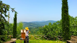 Une personne peignant en plein air, avec un paysage en arrière-plan.
