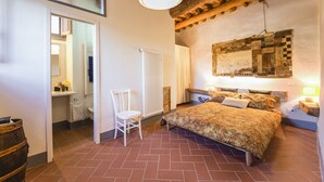 Une chambre à coucher avec un lit, une chaise, un radiateur et un plafond en bois.